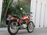 a red motorcycle parked in front of a white building