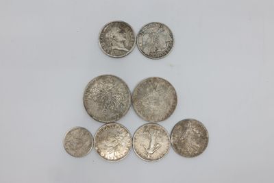 une pile de pièces d'argent posée sur une surface blanche