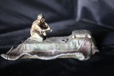 une figurine représentant un homme assis au bord d'un lit