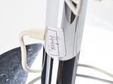 a whisk in a metal bowl with a tag on it