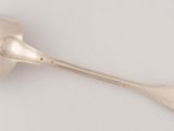 an antique silver spoon and spoon rest on a white surface
