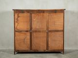 an image of a wooden chest of drawers against a wall