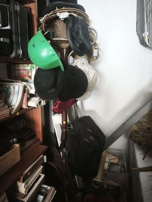 many hats hanging on a rack in a room