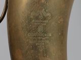 a close up of a brass vase with a black handle