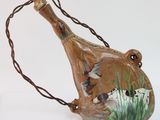 un vase marron orné d'oiseaux peints, posé sur une table