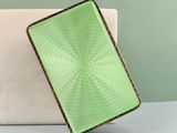 un sac à main vert posé sur une table à côté d'un ordinateur portable