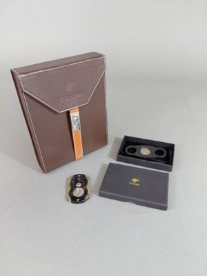 un étui marron contenant une montre et une autre montre à l'intérieur
