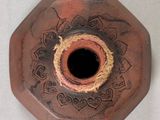 a brown vase with a black hole in the middle of it