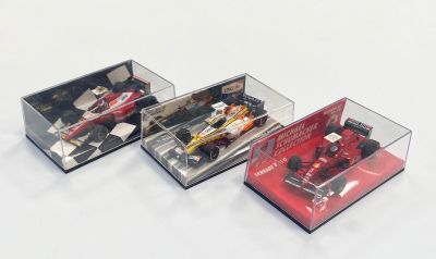 trois modèles différents de voitures de course dans une vitrine