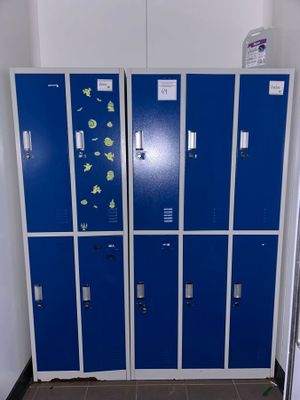 several blue lockers are lined up against a wall in a room