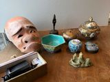 une table en bois sur laquelle sont posés un masque et d'autres objets