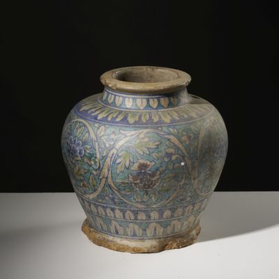a blue and green vase sitting on a white table