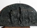 une sculpture représentant un groupe de personnes, posée sur un socle en bois