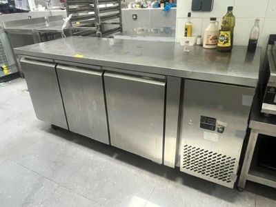 a stainless steel counter in a kitchen with a wine bottle on it