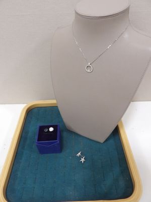 un collier, une bague et un écrin à bague exposés dans une vitrine