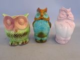trois figurines de chouettes de couleurs différentes, posées les unes à côté des autres sur une table