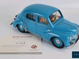 a blue toy car that is sitting next to a card