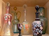 de nombreux vases de toutes sortes posés sur une étagère dans un meuble
