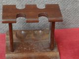 un petit présentoir en bois avec une paire de chaussures à côté