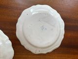 two white plates on a wooden table with one of them broken