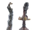 deux statues représentant une femme et un homme, posées sur un socle