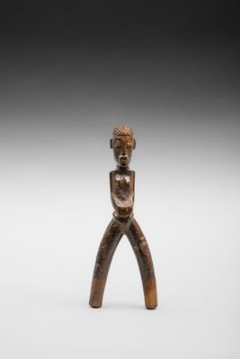 une petite figurine en bois représentant un homme tenant un couteau