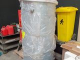 un grand réservoir métallique posé sur une palette dans un entrepôt