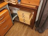 a desk with a file cabinet and drawers in the corner