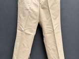 une photo d'un pantalon beige suspendu à une corde à linge