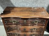 une petite commode en bois exposée dans une pièce