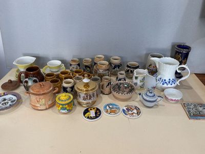 une table sur laquelle sont disposés de nombreux objets en poterie de styles variés