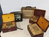 quatre valises posées sur une table où se trouve une radio