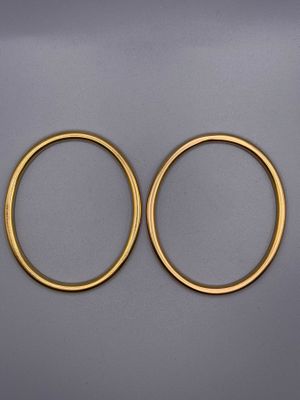 une paire de boucles d'oreilles créoles en or sur fond gris