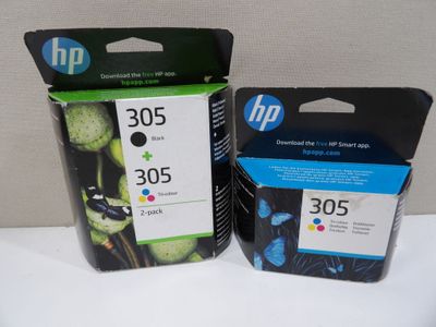 two black and one color ink cartridges are sitting on top of each other