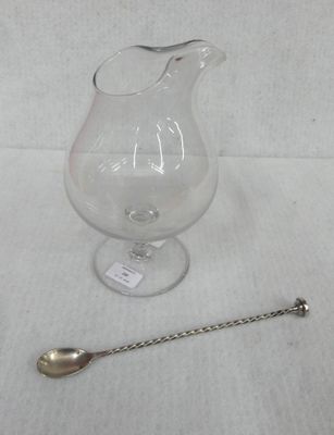 a glass pitcher and a spoon on a table