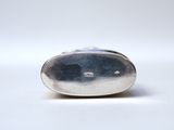 a close up of a silver object on a white surface