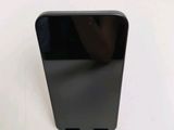 the back of a black cell phone sitting on top of a white table