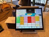 une tablette posée sur un comptoir, à côté d'une calculatrice