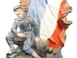 a statue of a man sitting on a bench with a flag in the background