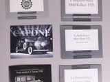 several business cards with pictures of old cars on them on a table