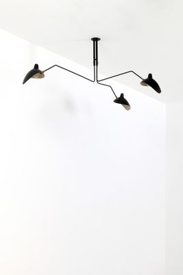 two black and white lights hang from the ceiling in a white room