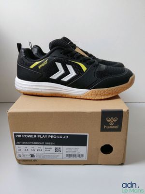 La boîte contient une paire de baskets noires et jaunes.
