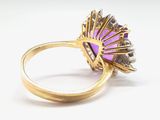 an image of a gold ring with a purple stone surrounded by diamonds