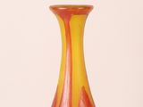 a red and yellow glass vase sitting on a table
