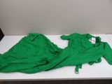 a green shirt sitting on a white table in a room