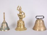 three bells sitting next to each other on a white surface