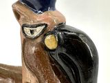 a ceramic bird with a blue hat on it ' s head