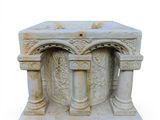 a white marble pedestal with columns and a cross on it