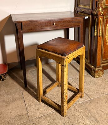 un petit tabouret en bois posé à côté d'une petite table