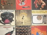many different album covers on the wall of a room